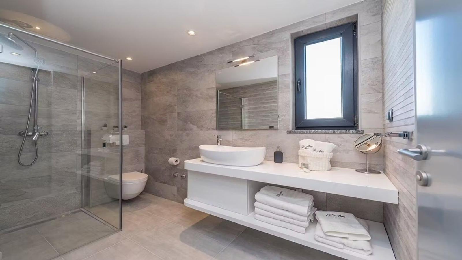 Bathroom with shower, sink, and window