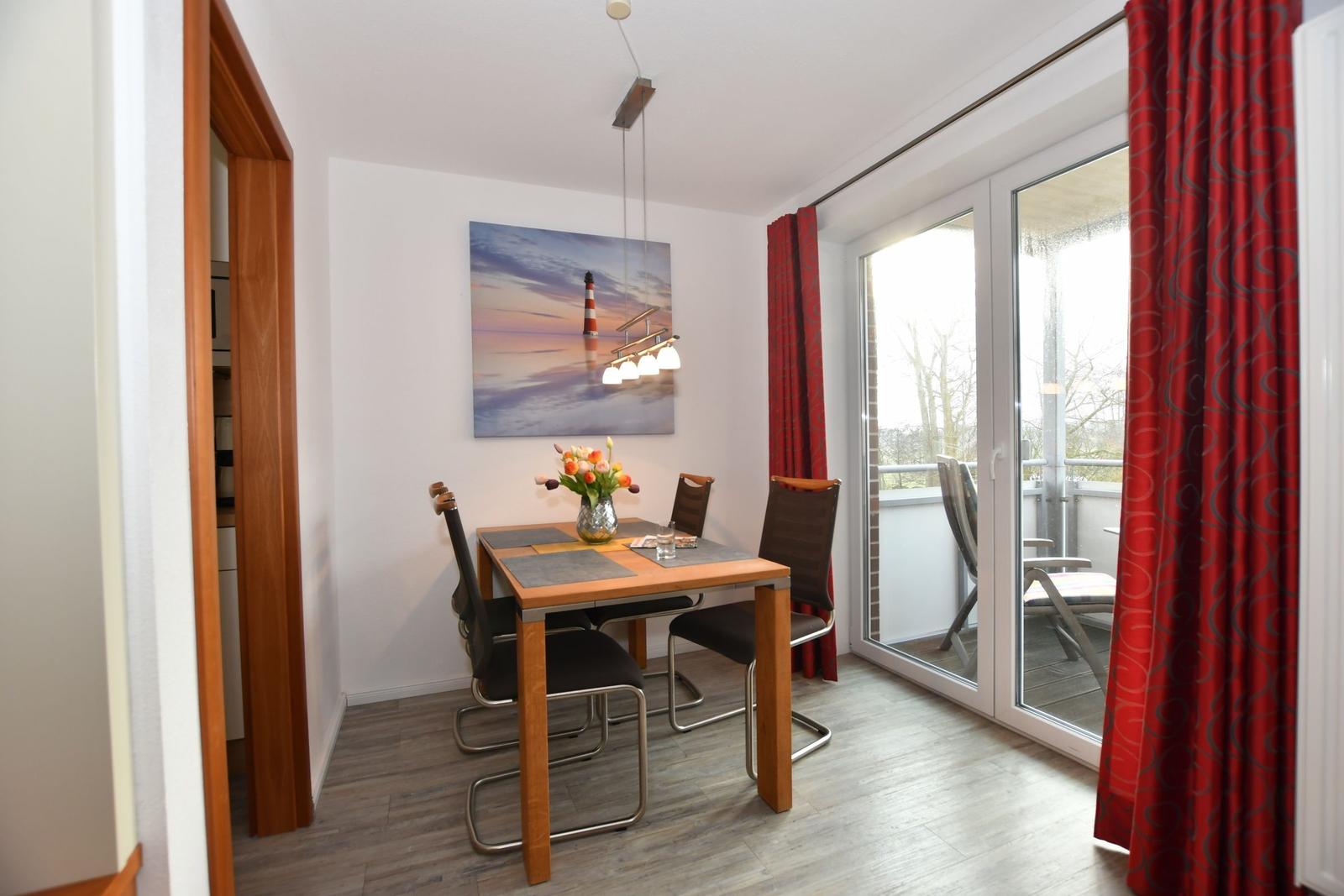 Essbereich mit Tisch, Stühlen und Blick auf Balkon