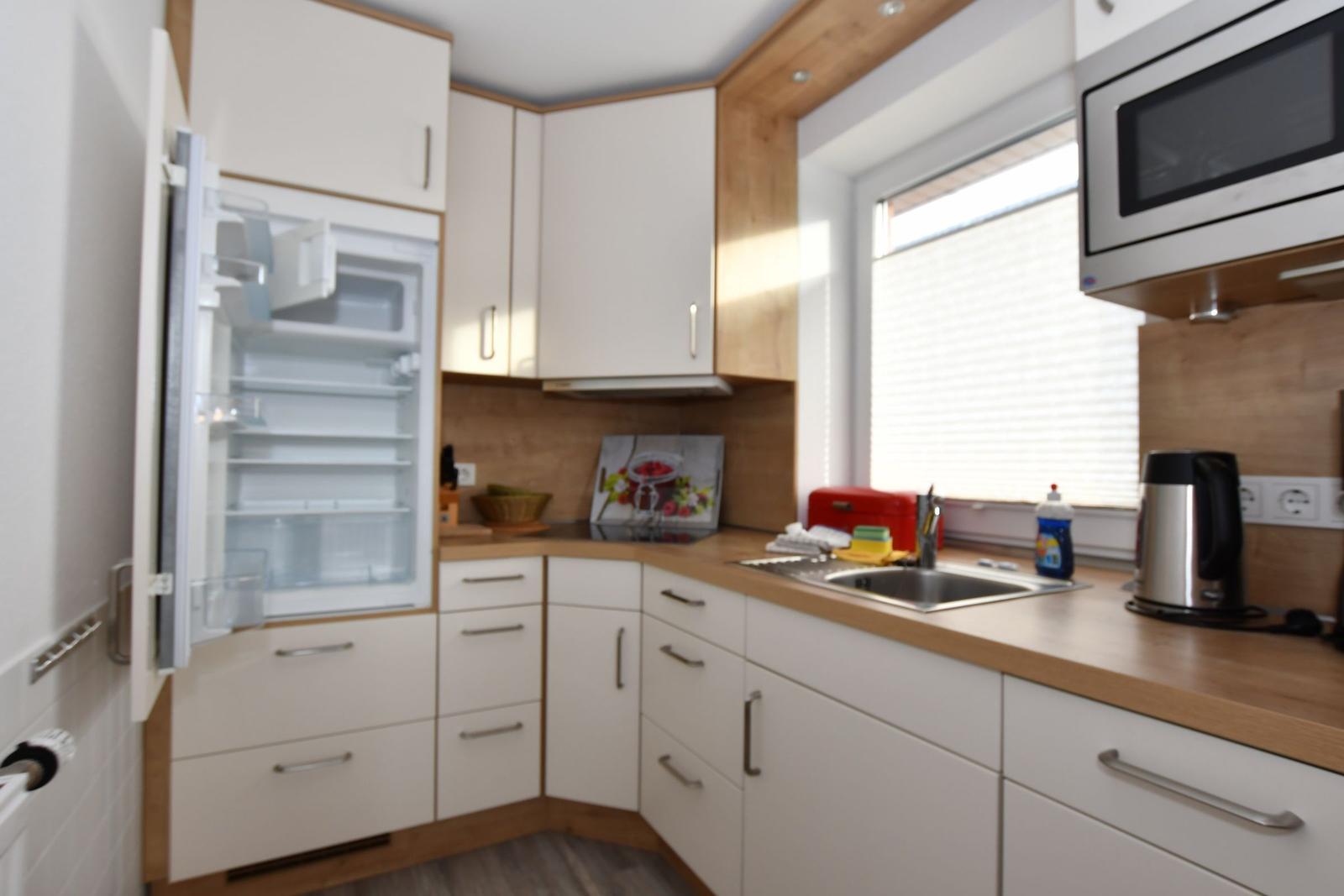 Küche mit Kühlschrank, Spüle und Mikrowelle