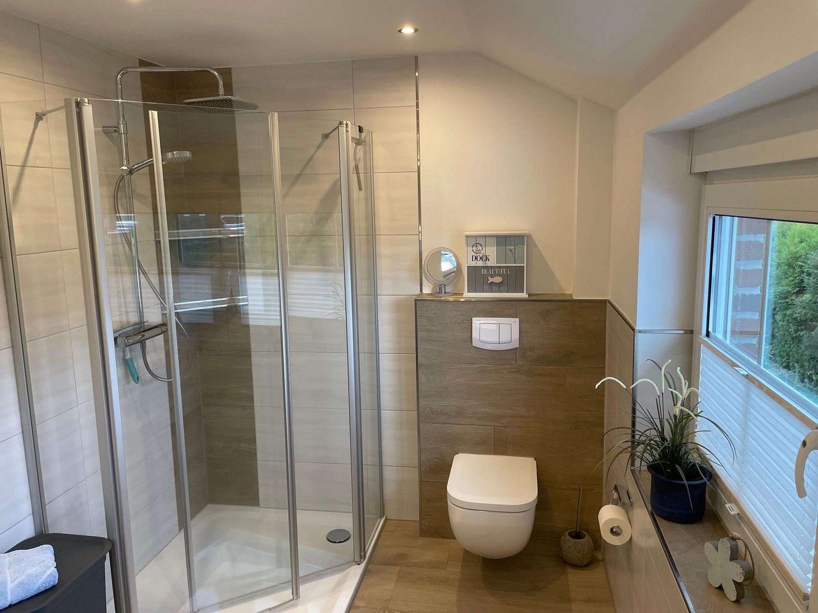 Bad mit Dusche, WC und Fenster mit Pflanze