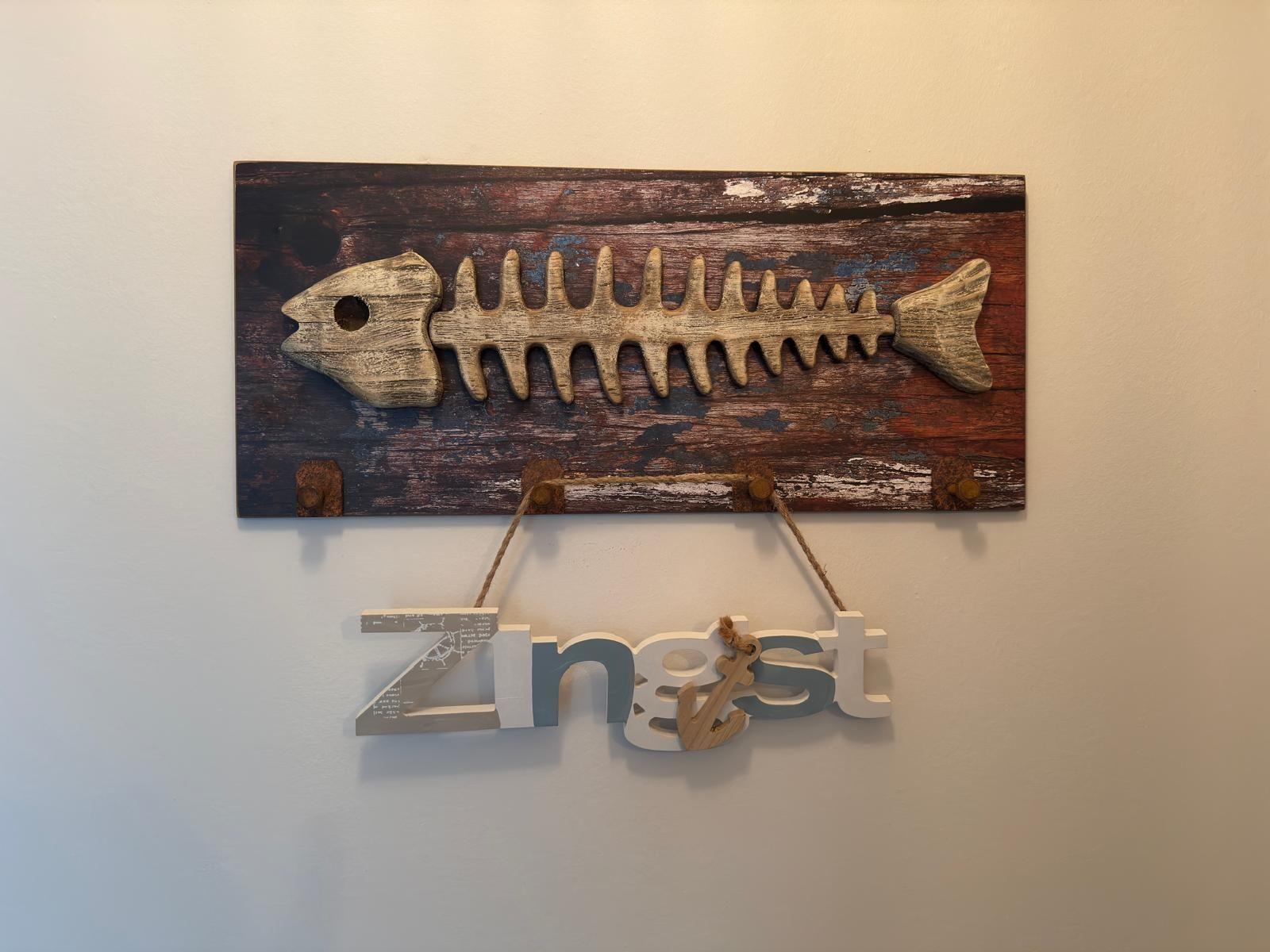 Wanddekoration mit Fischskelett und dem Schriftzug Zingst