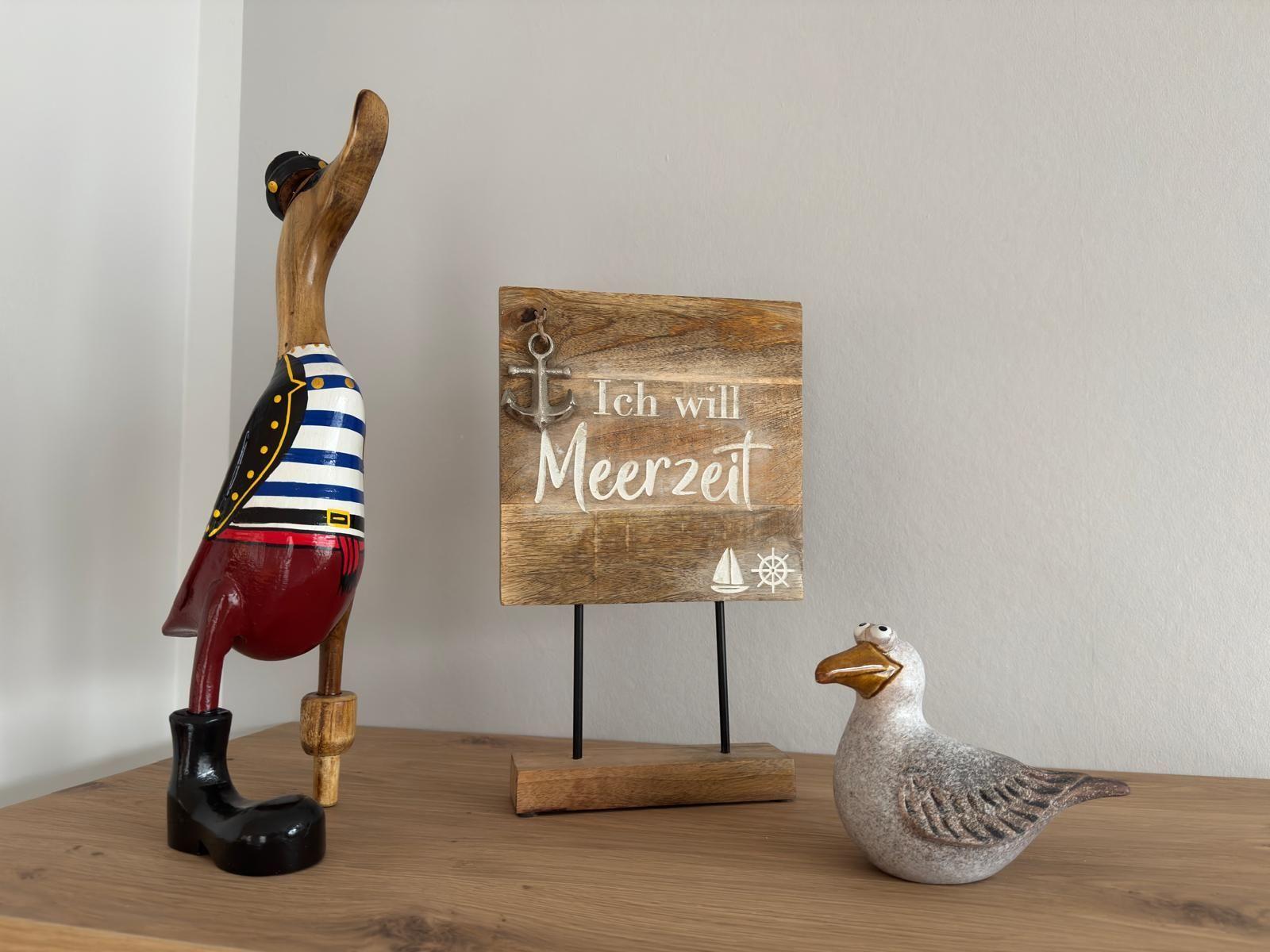 Holzdekoration mit Seemöwenfigur und Schild mit Meerzeitschrift.