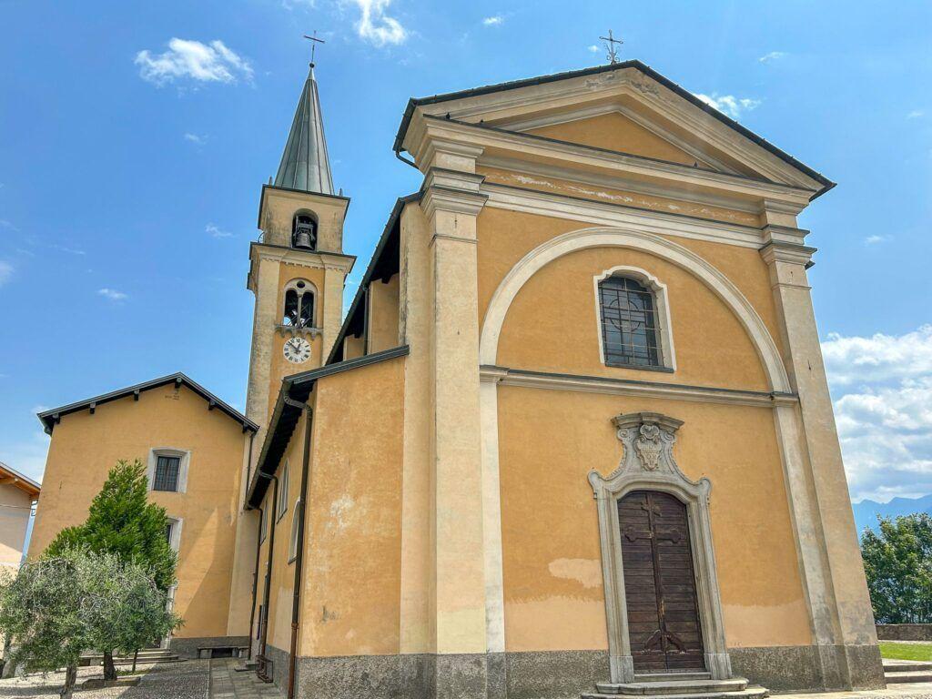 Eine Kirche mit Turm und Eingangstür unter blauem Himmel.