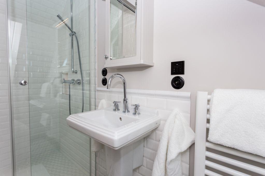 Badezimmer mit Dusche, Waschbecken und Handtuchheizung.