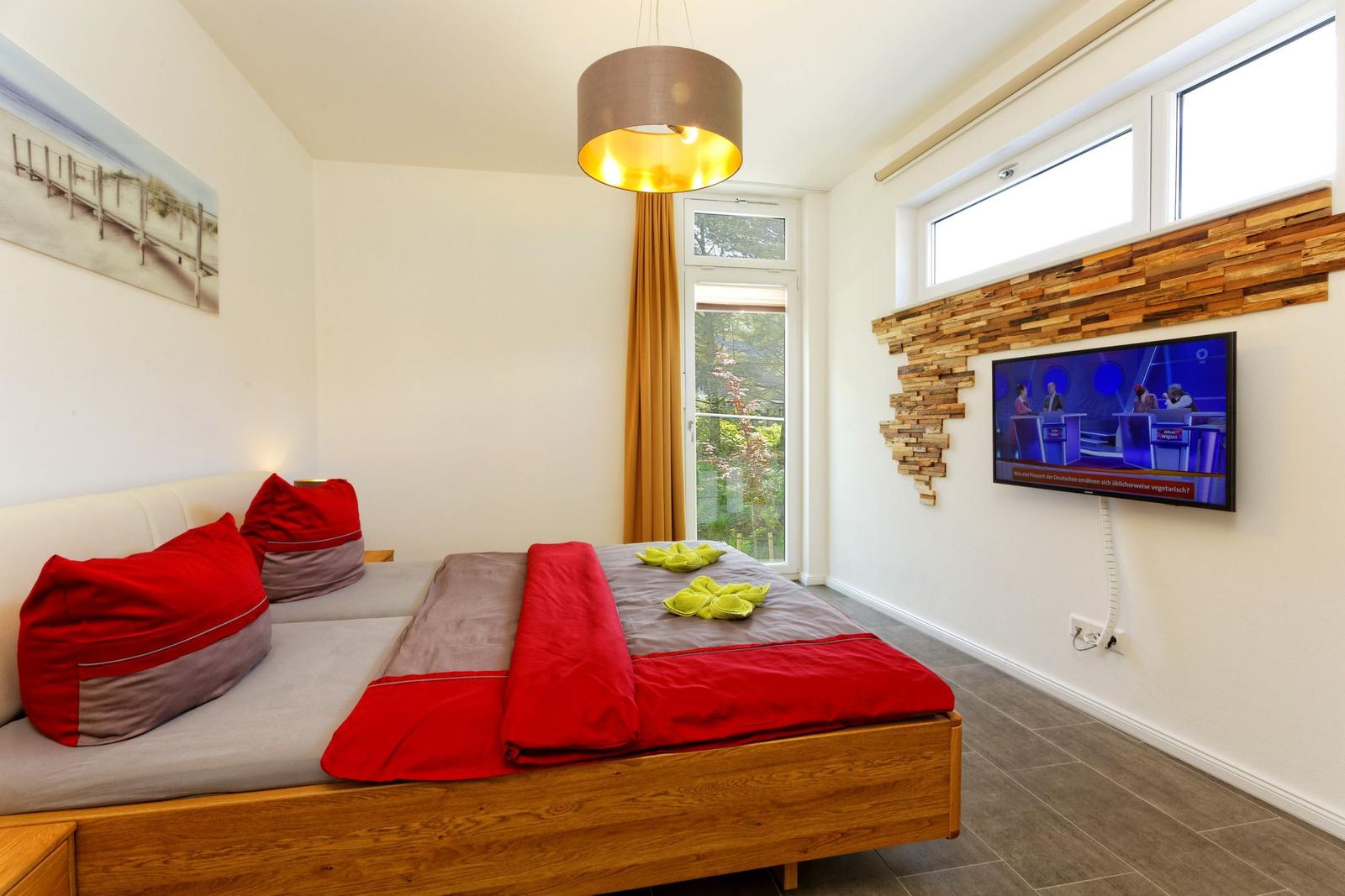 Schlafzimmer mit Doppelbett und Flatscreen TV