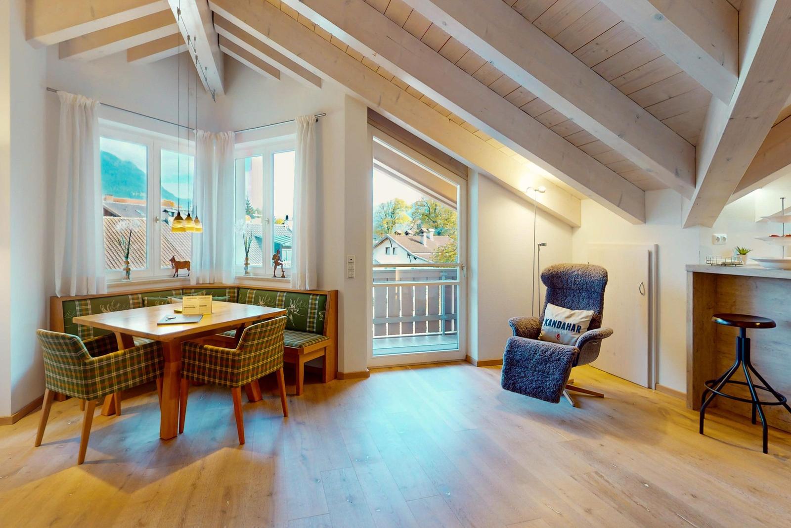 Essbereich mit Tisch, Stühlen und Sitzbank. Balkon und Wohnbereich mit Sessel.