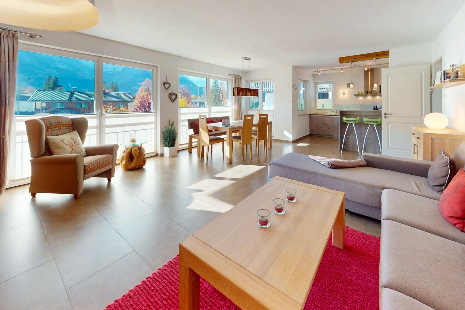 Wohn- und Essbereich mit Balkonblick, Küche und Schlafzimmer im Hintergrund.