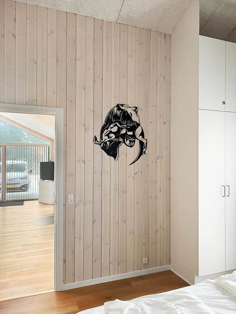 Schlafzimmer mit Holzwand, Wanddekoration und weißen Schränken.