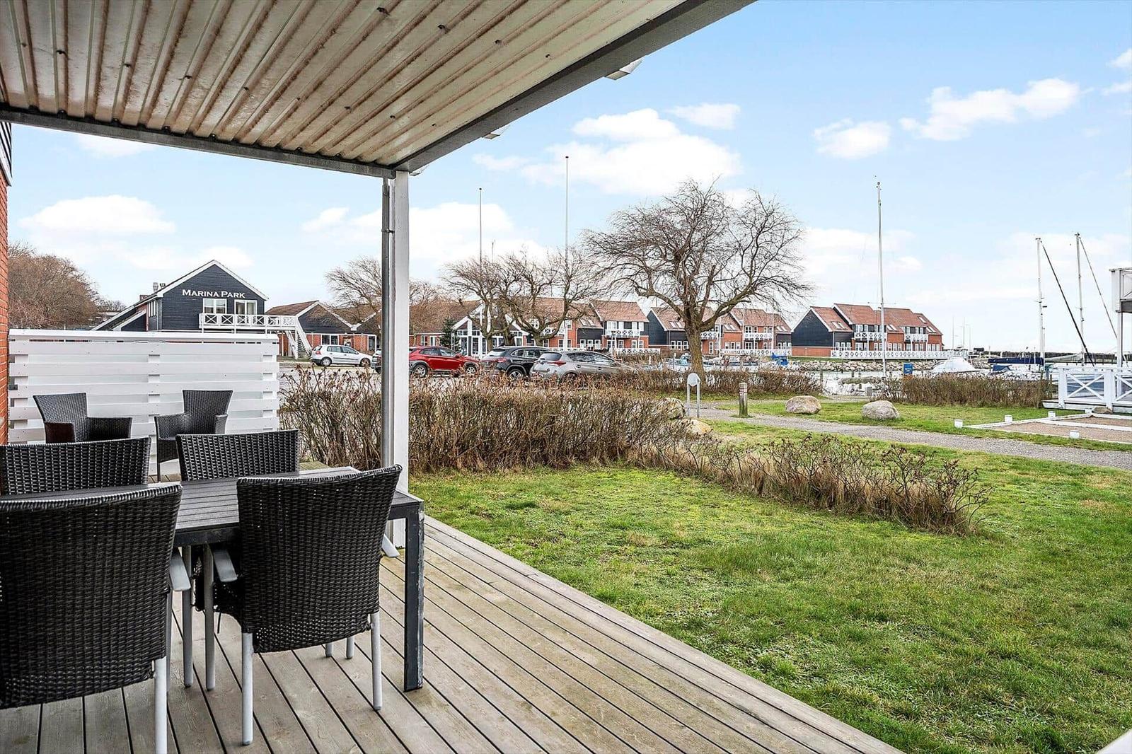 Terrasse mit Tisch und Stühlen. Blick auf Marina Park und Hafen.