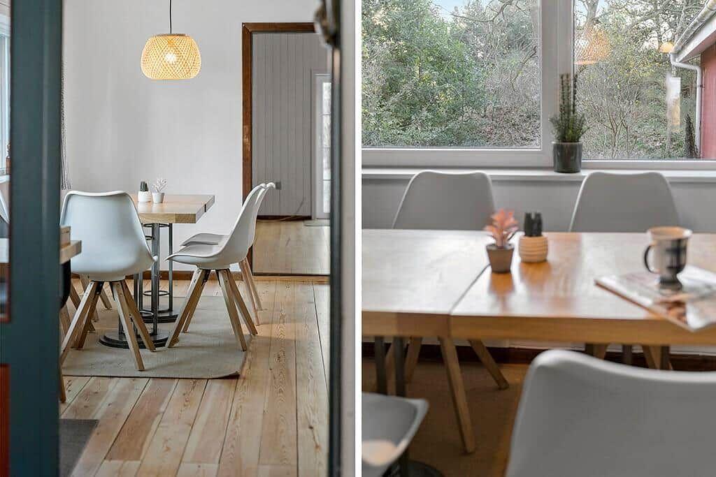 Essbereich mit Holztisch, weißen Stühlen und Fensterblick auf Grün