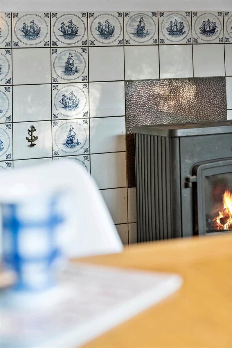 Wohnzimmer mit Kachelwand und Kaminofen