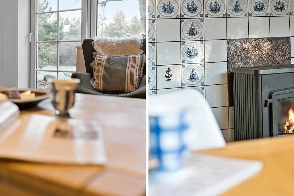 Sitzgelegenheit mit Kissen vor Fenster und Kamin mit Segelbootfliesen