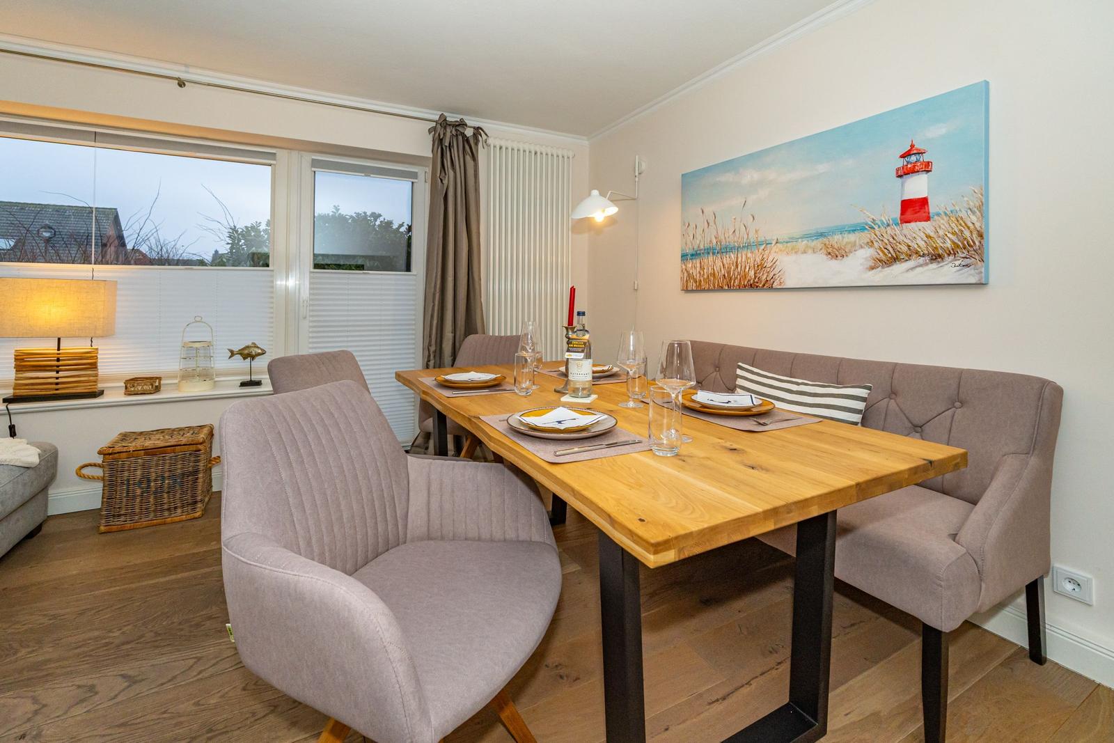 Esstisch mit Stühlen und Wandbild mit Leuchtturm