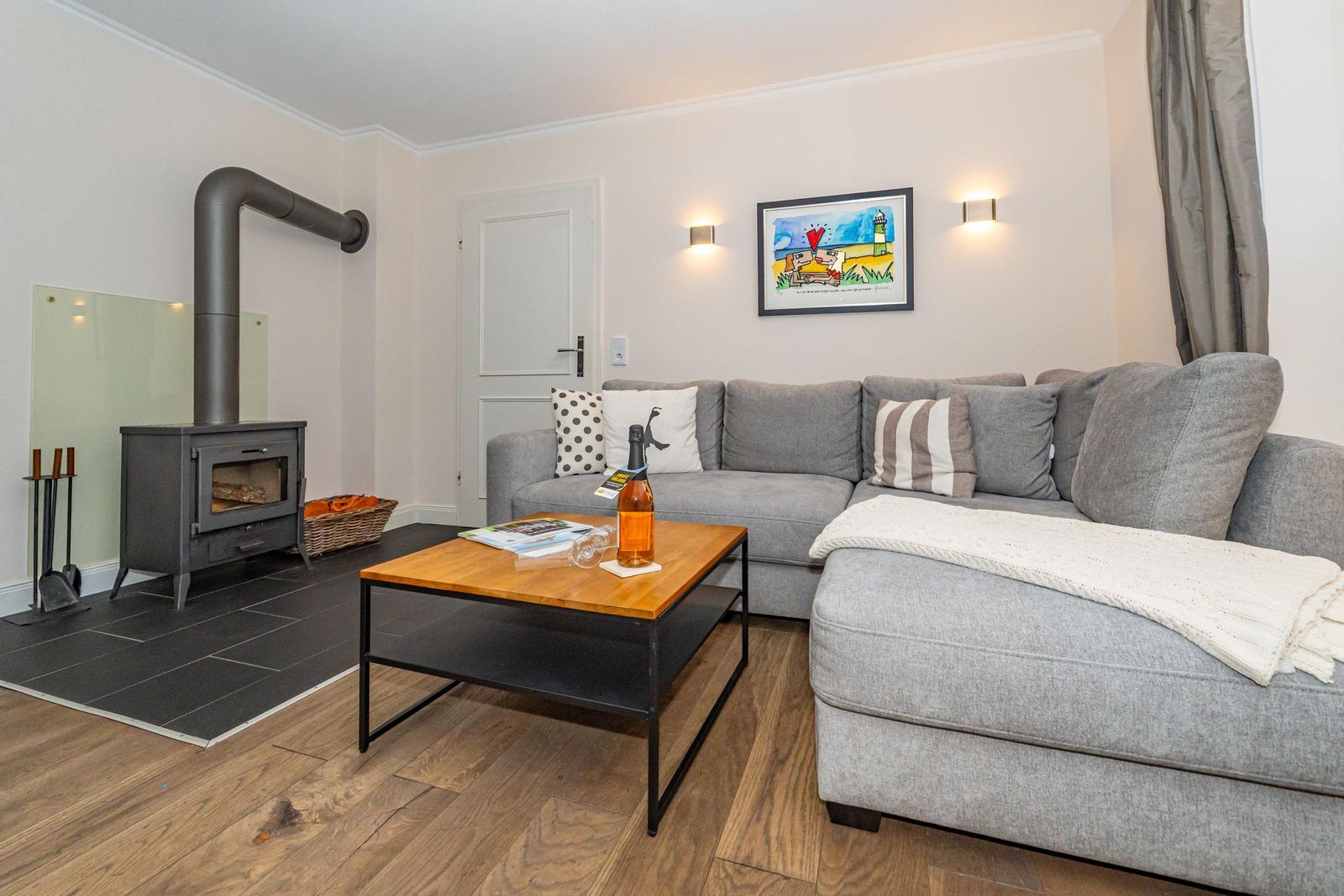 Wohnzimmer mit Sofa, Kamin und Couchtisch.