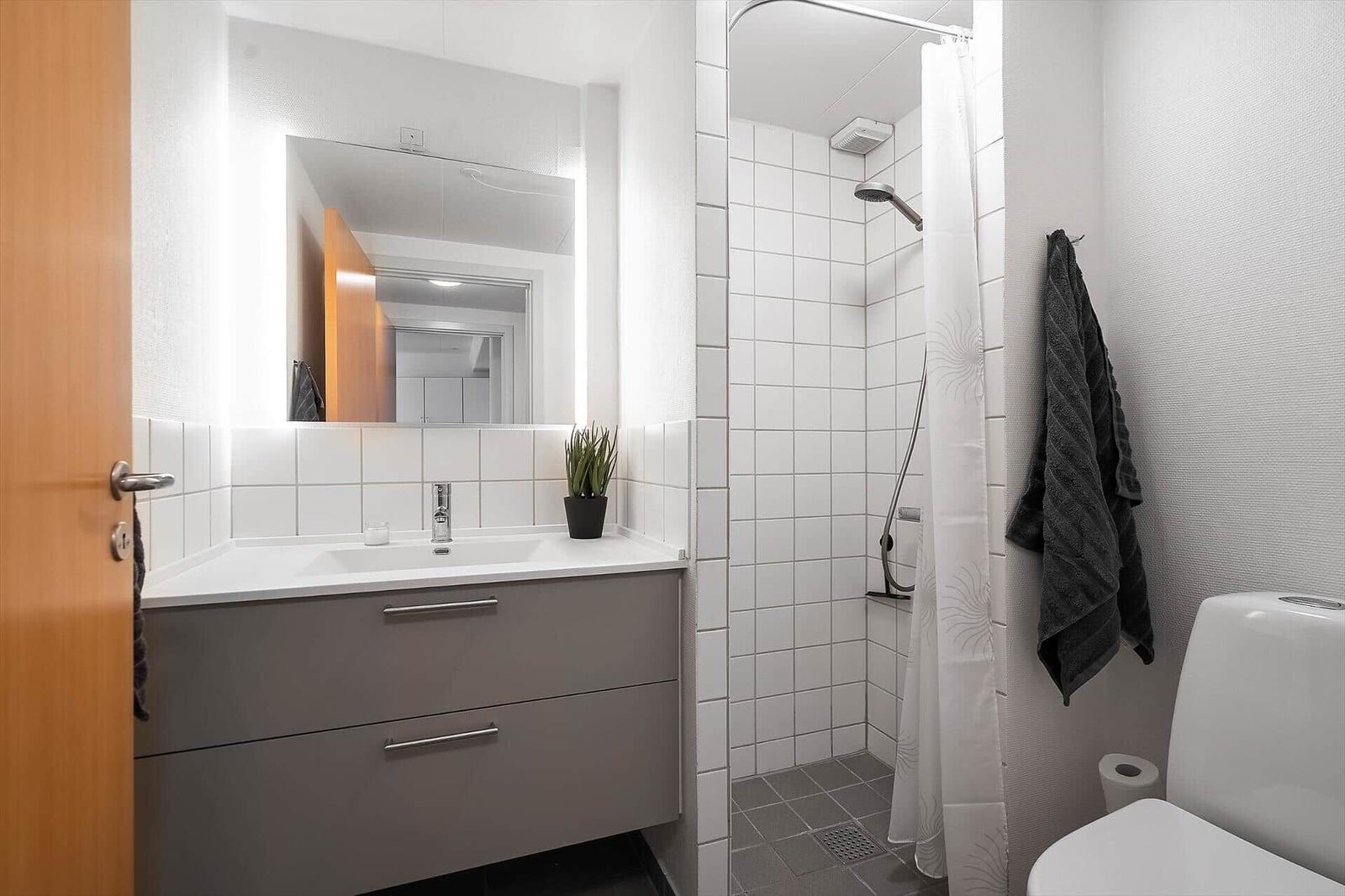 Badezimmer mit Dusche, Waschbecken und Toilette.