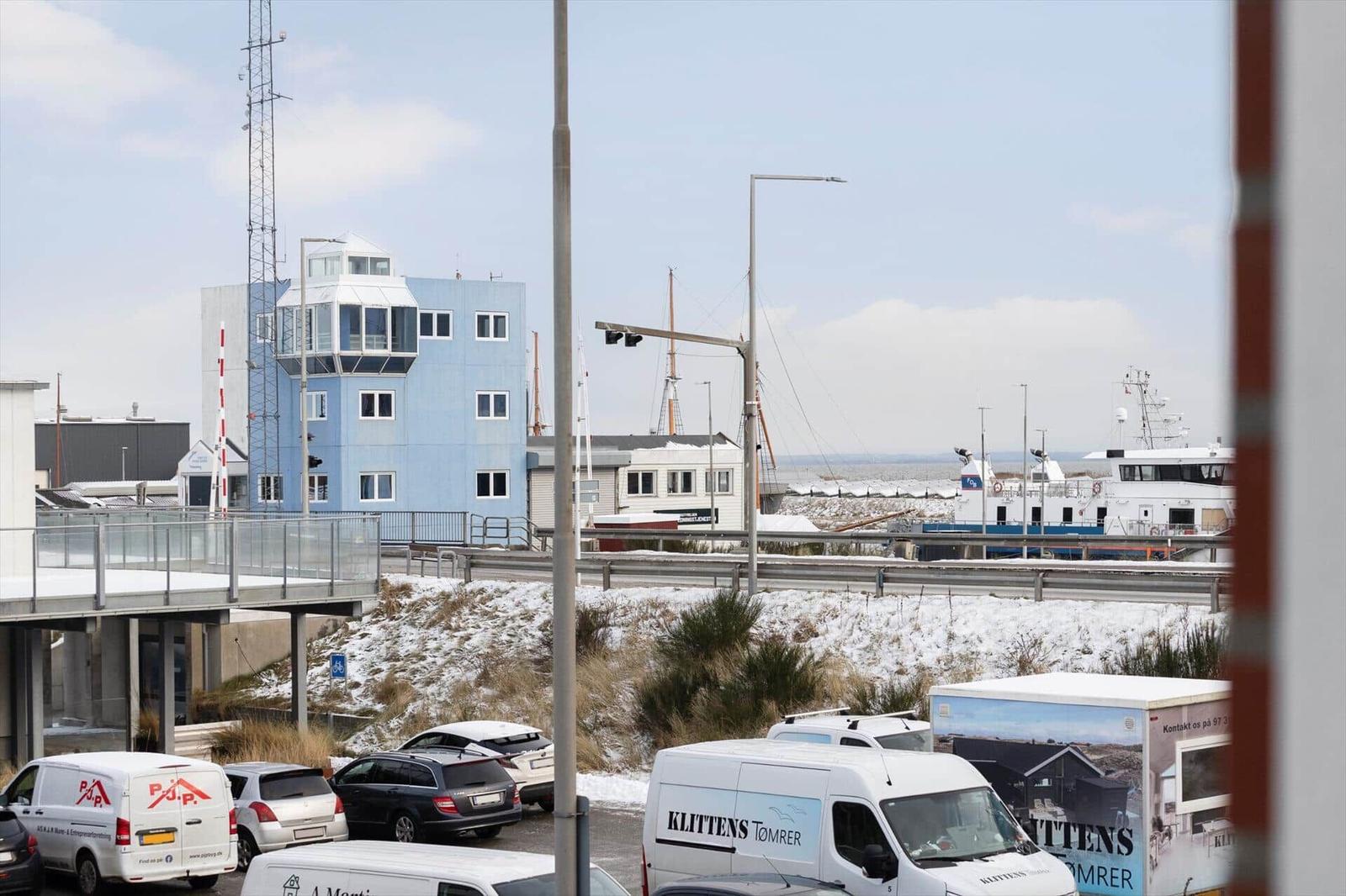 Blick auf Hafen mit Schiffen und blauem Gebäude im Hintergrund.