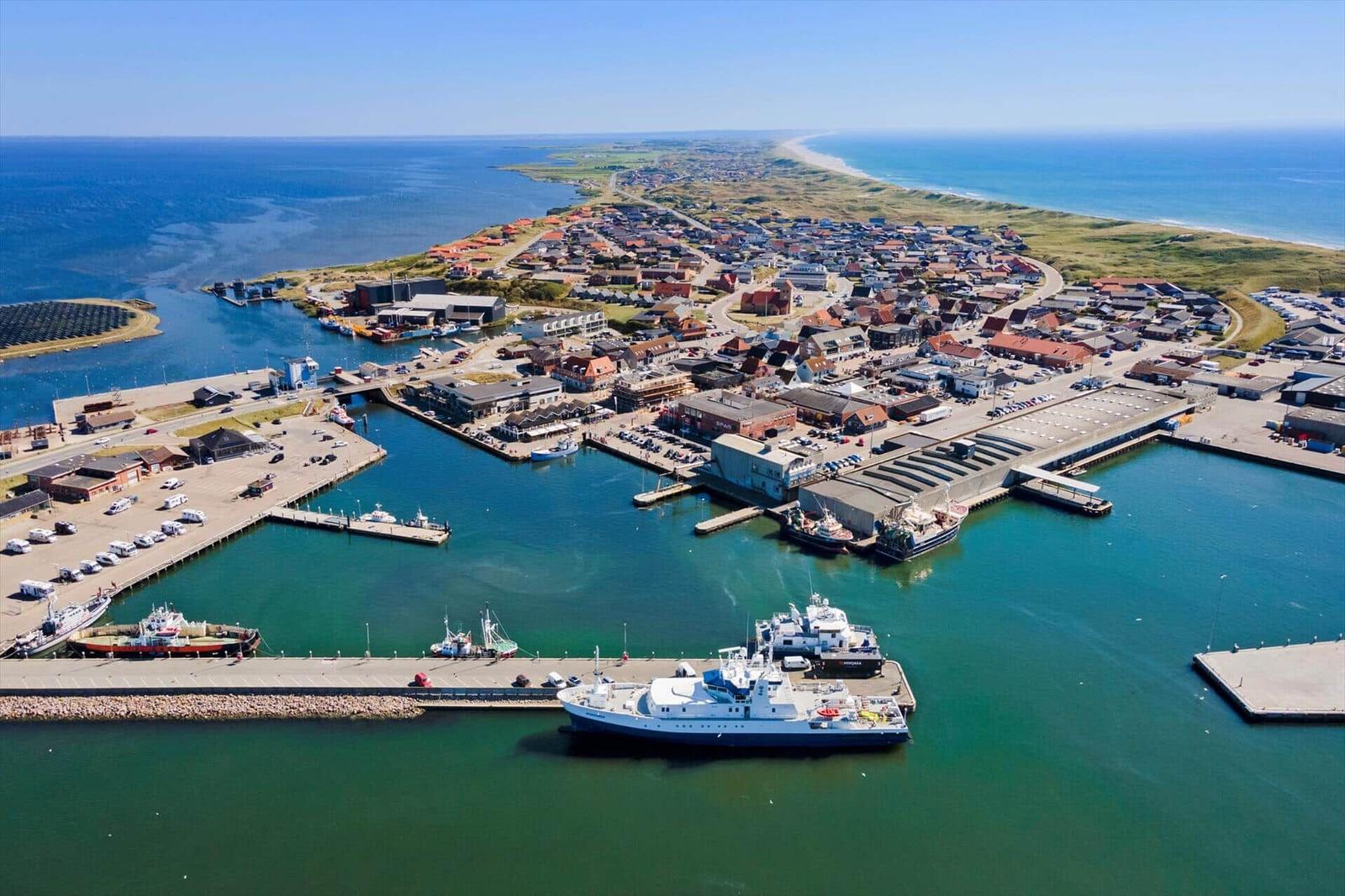 Hafenstadt mit Booten und Strand im Hintergrund