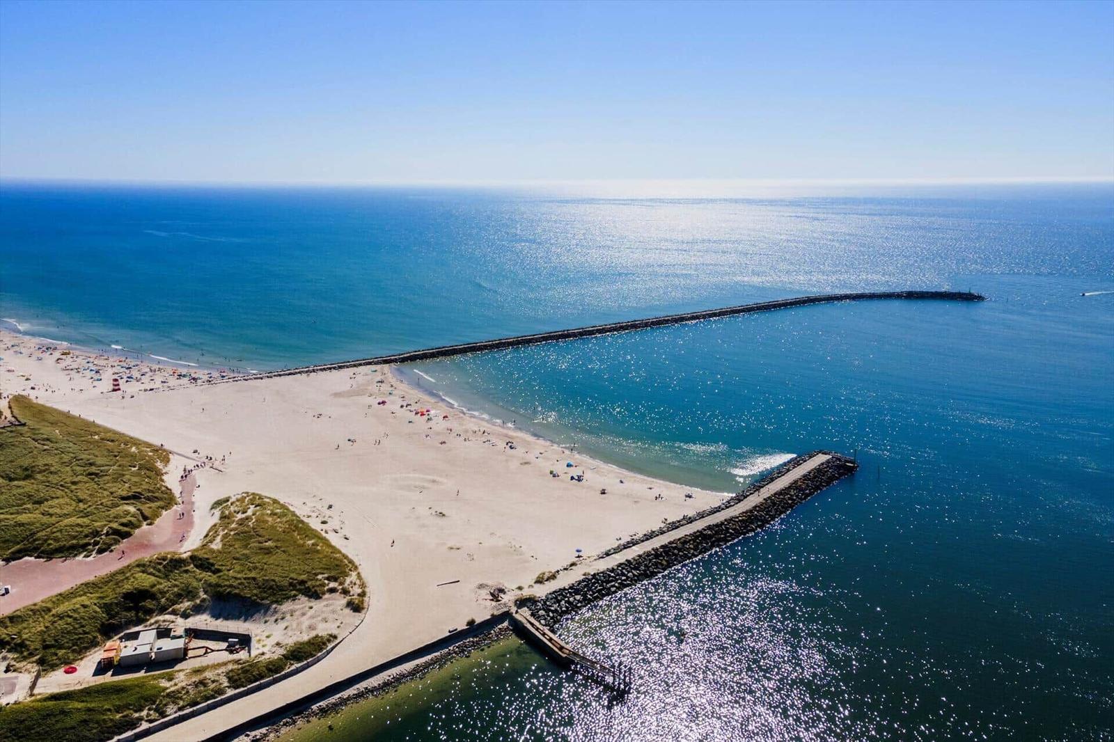 Strand mit Steinhafen und sonnigem Meer