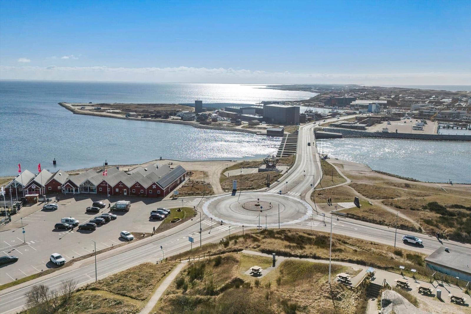 Hafenstadt mit roten Häusern, Straßenkreuzung und Blick aufs Meer.