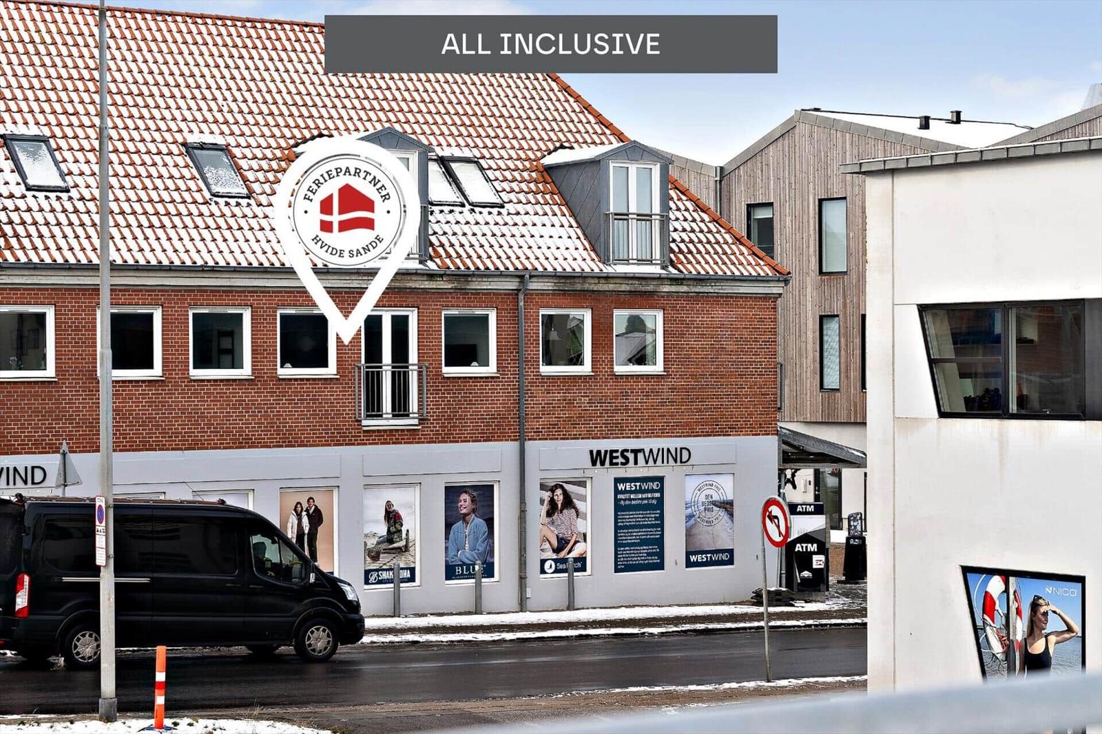 Ferienhaus mit rotem Dach und weißen Fenstern in Hvide Sande.