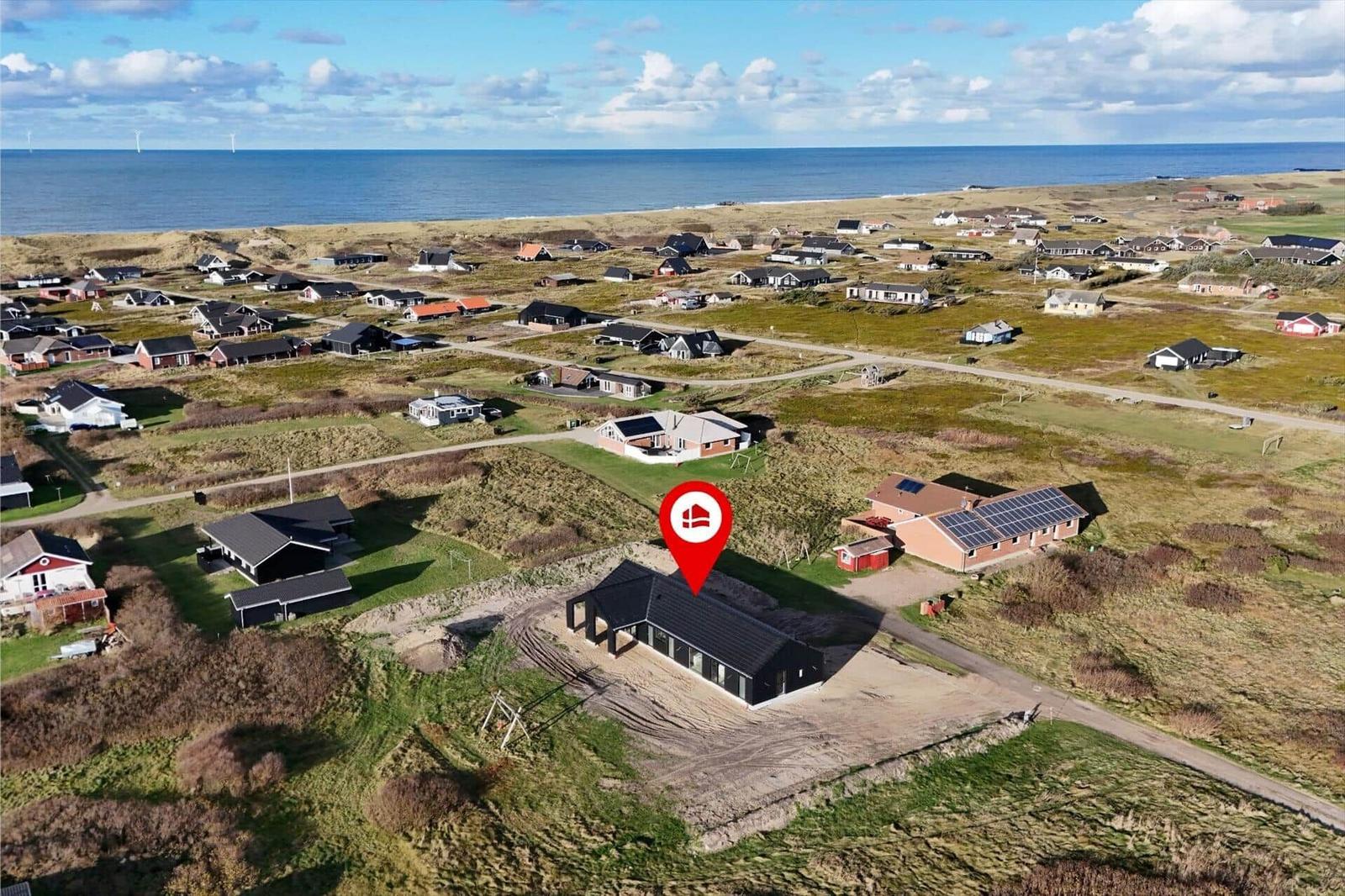 Modernes Haus mit Solaranlage an Strandlage mit Blick aufs Meer.