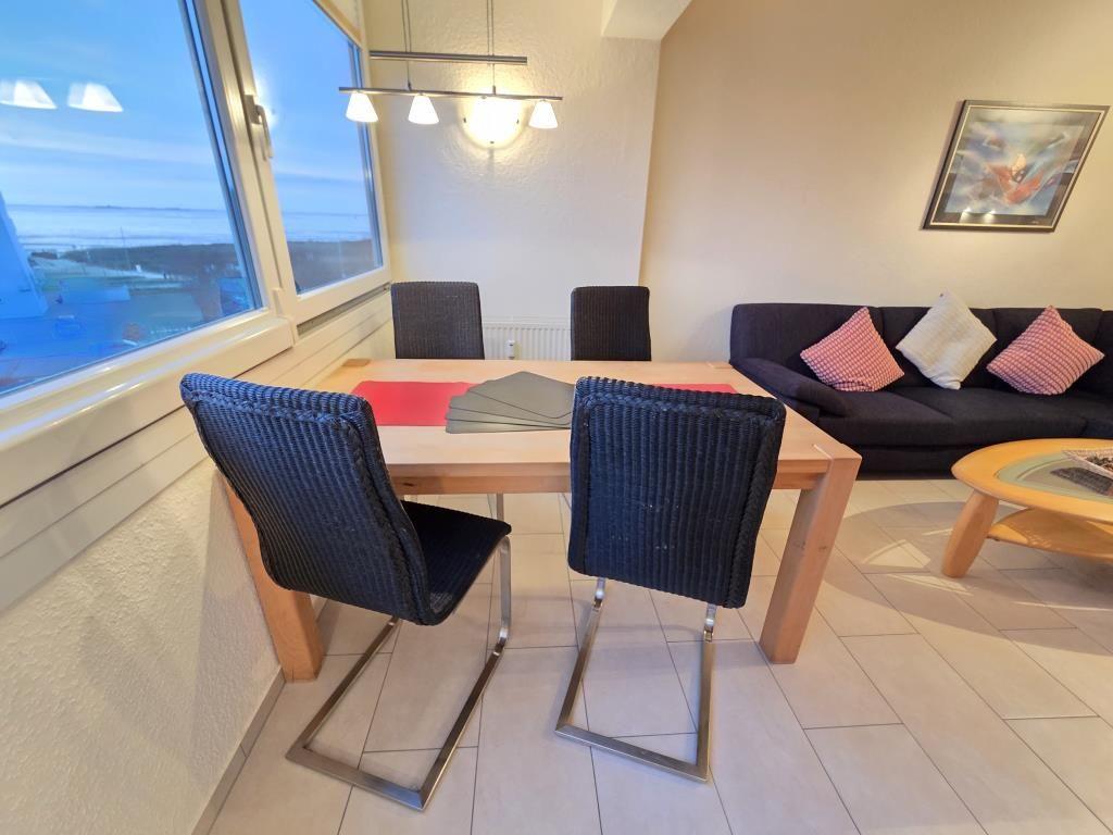 Essbereich mit Tisch und Stühlen. Wohnbereich mit Sofa und Couchtisch. Große Fenster mit Blick.