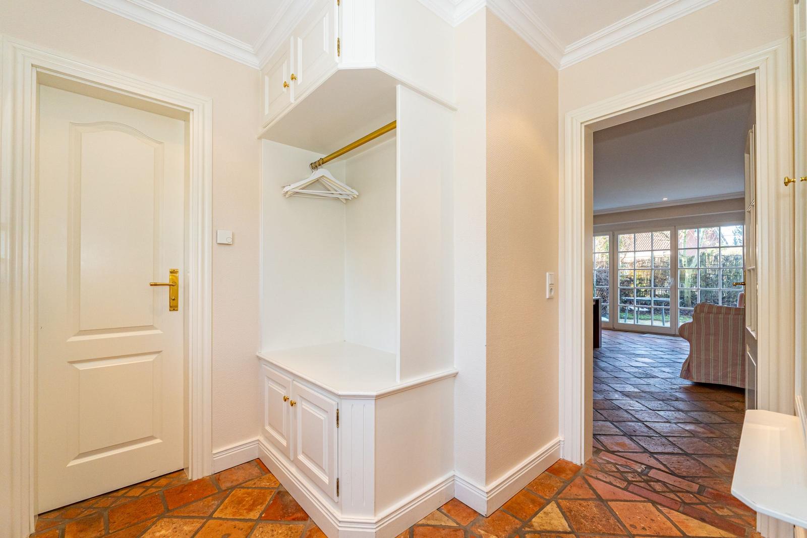 Eingangsbereich mit Kleiderschrank und Tür zur Wohnfläche.