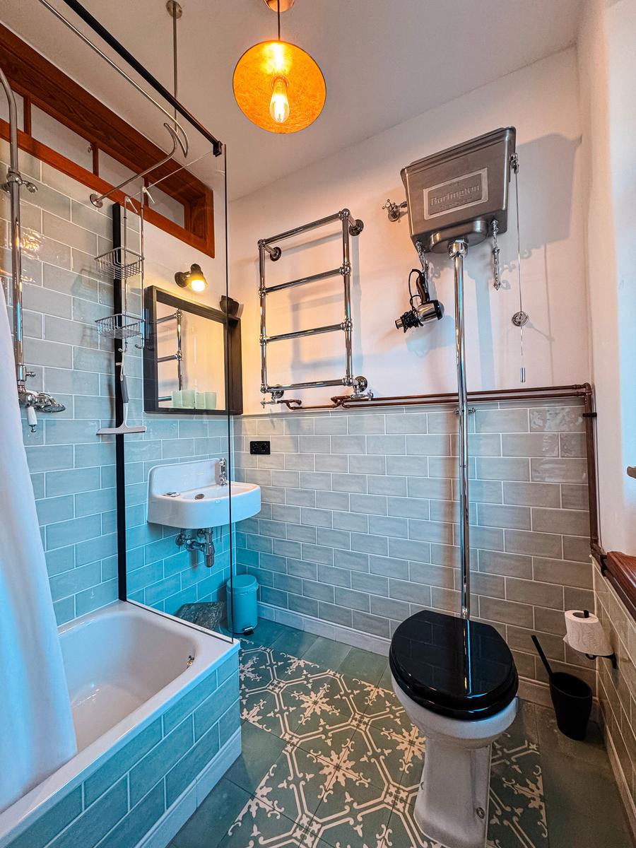 Bad mit Badewanne, Toilette und Waschbecken. Wandfliesen und Bodenfliesen.