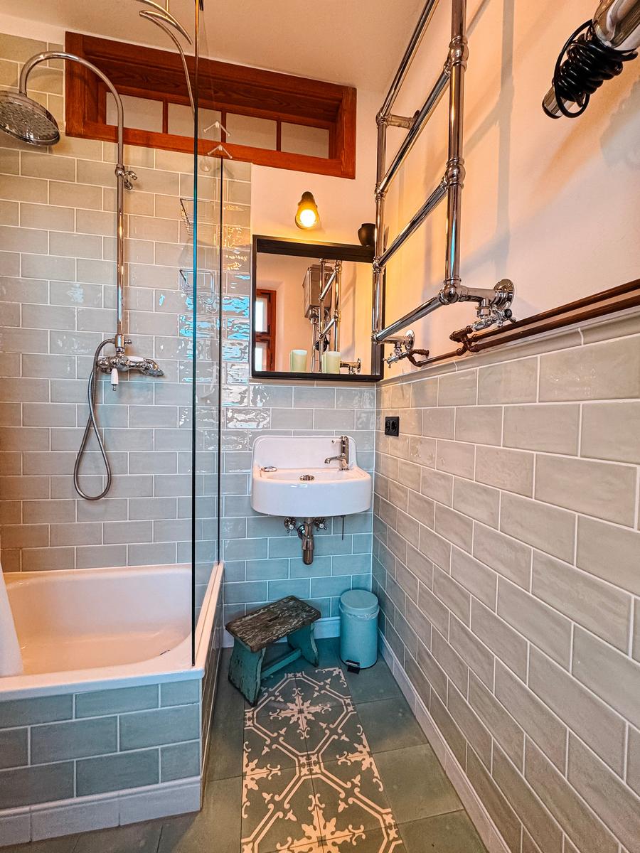 Badezimmer mit Badewanne, Dusche, Waschbecken und Spiegel.