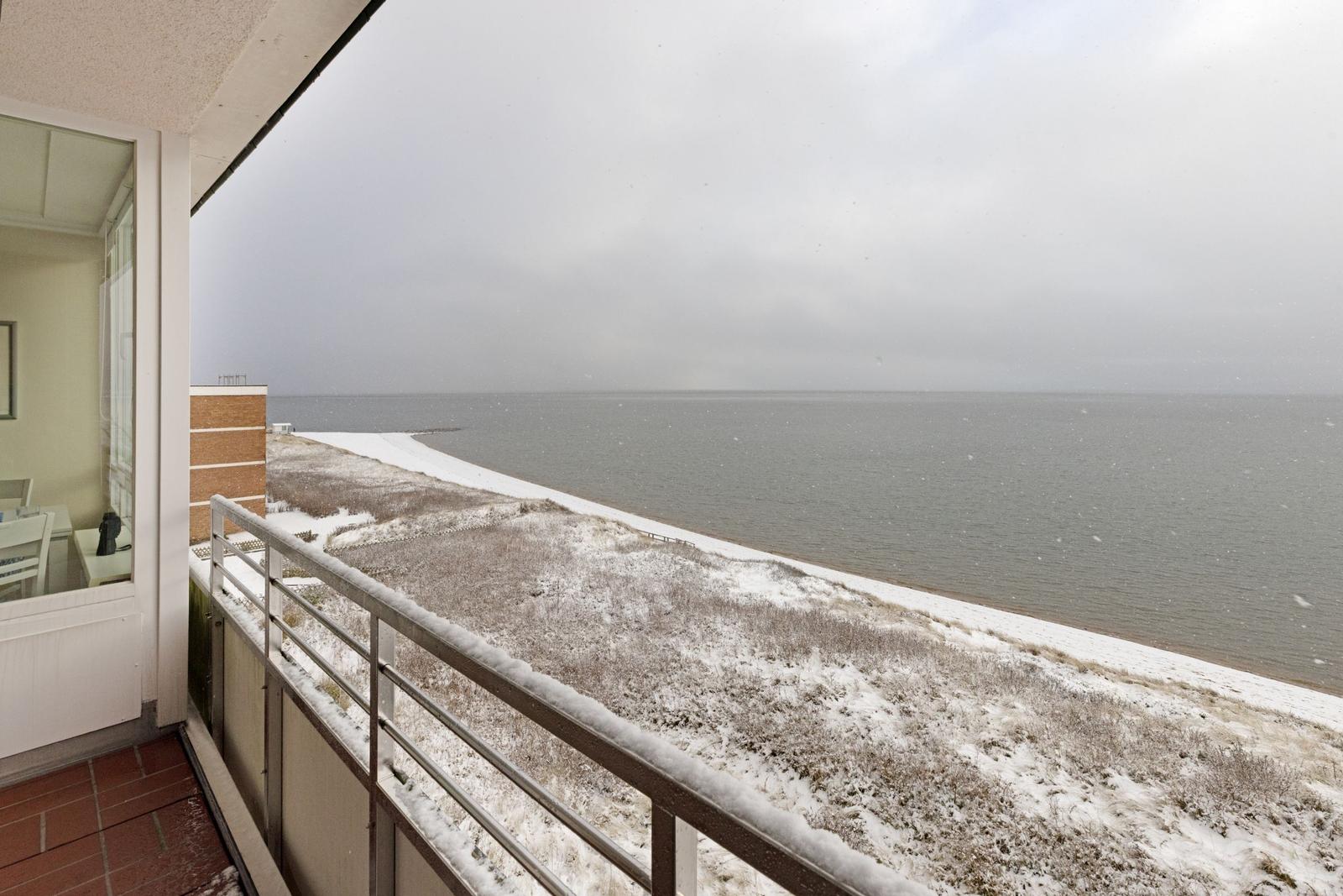 Balkon mit Blick auf schneebedeckten Strand und Meer