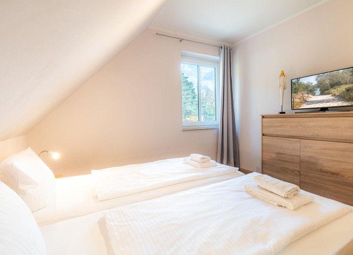 Zimmer mit Doppelbett, Fenster und Fernseher auf Schrank