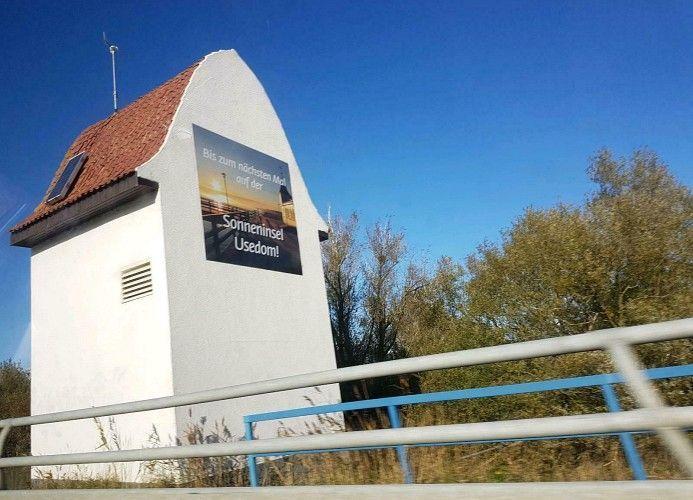 Weißer Turm mit rotem Dach und Werbeplakat für Usedom