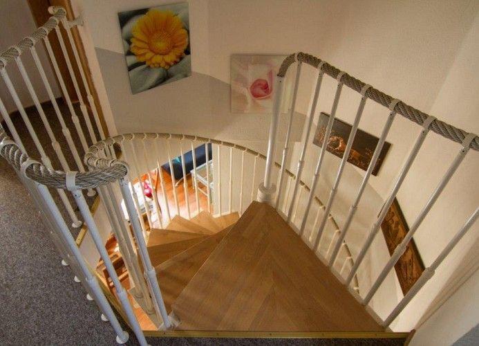 Hölzerner Wendeltreppe mit weißen Geländern und Wandbildern