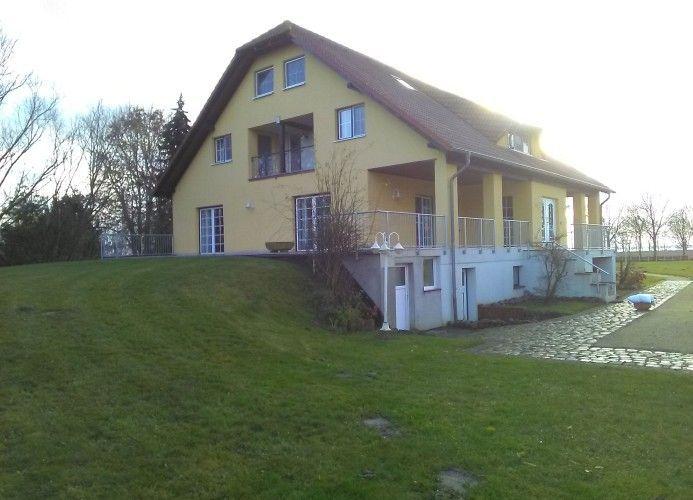 Einfamilienhaus mit Terrasse und Garten. Eingangstreppe und Fenster sind sichtbar.