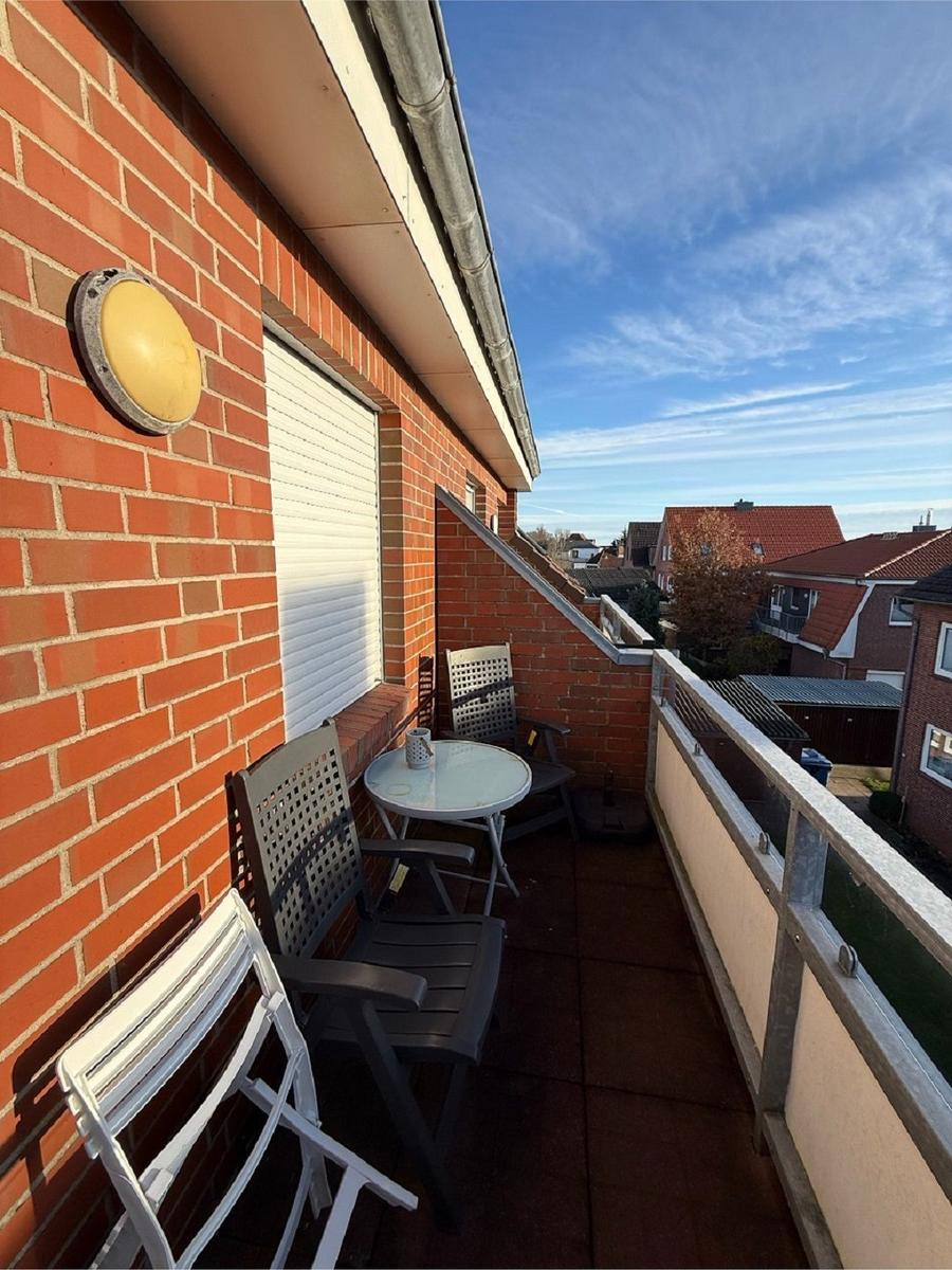 Terrasse mit Tisch, Stühlen und Blick auf die Nachbarschaft.