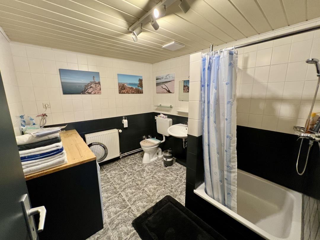 Badezimmer mit Badewanne, Dusche, Toilette und Waschbecken.