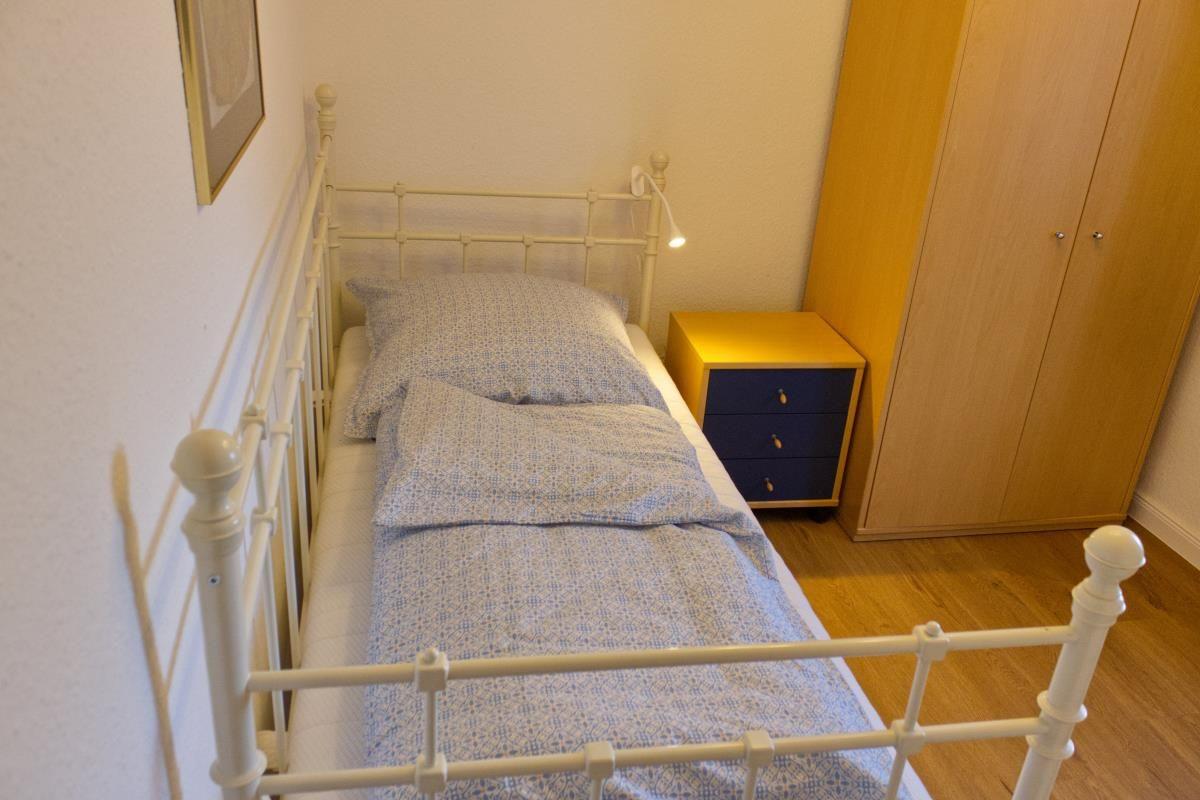 Ein Schlafzimmer mit einem Bett, Nachttisch und Kleiderschrank.