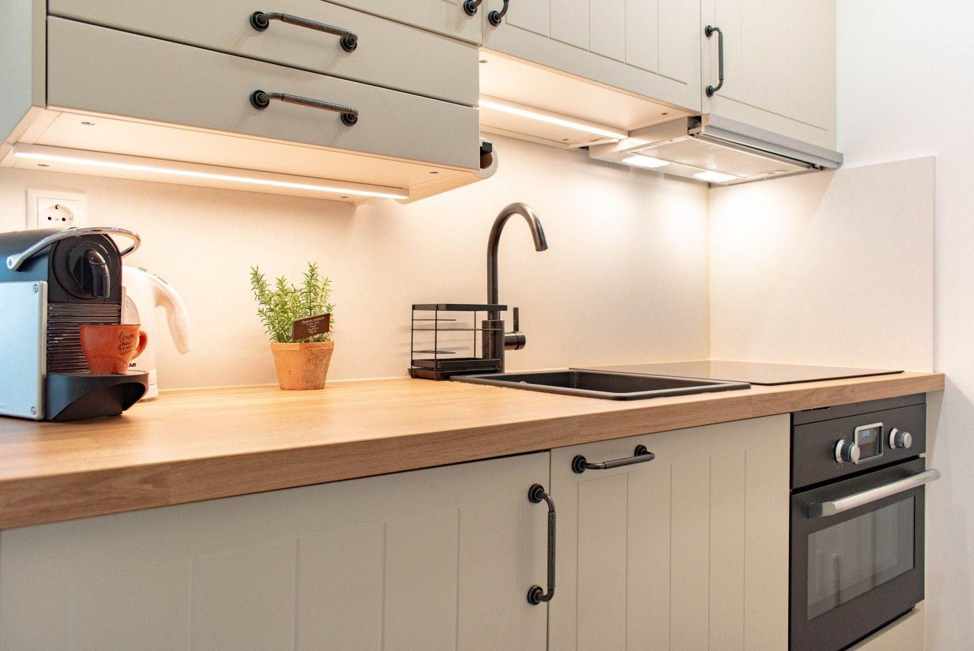 Küche mit Holzoberfläche, Edelstahlspüle und integriertem Ofen.