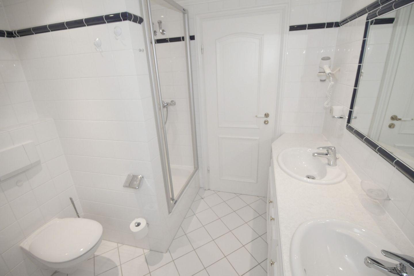 Badezimmer mit Dusche, Toilette und Waschbecken