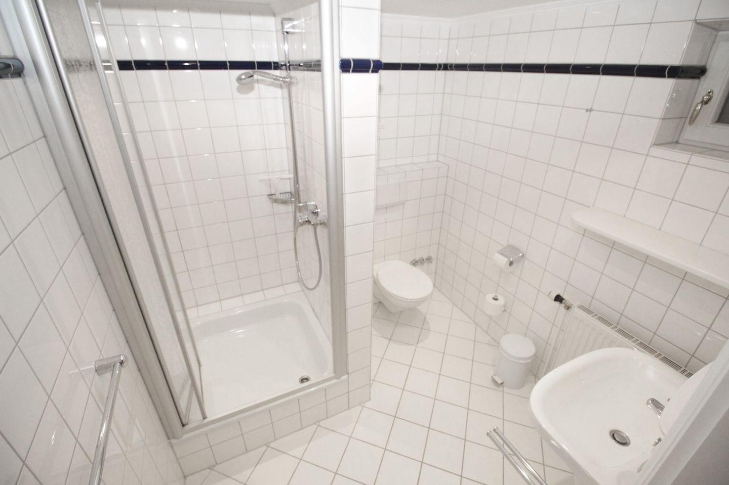 Badezimmer mit Dusche, Toilette und Waschbecken