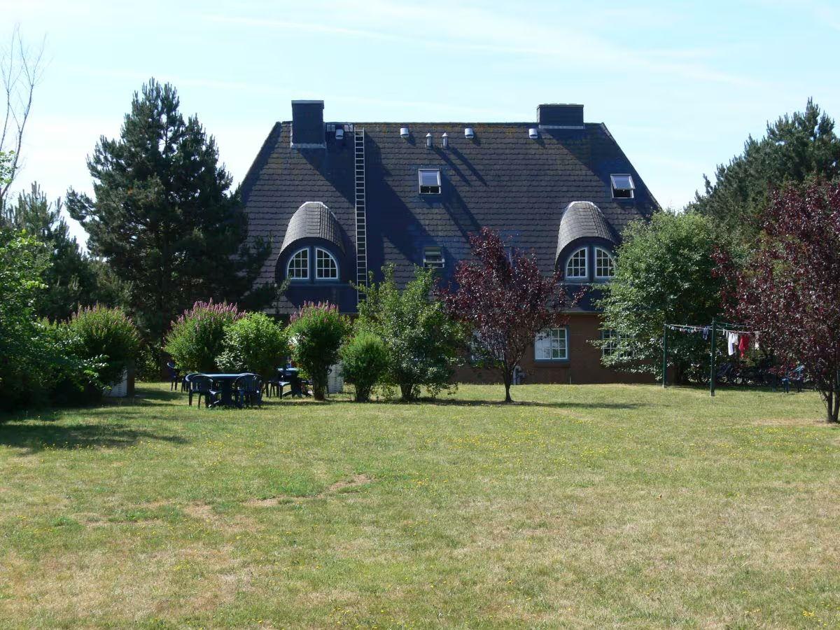 House with dark roof, garden table, and clothesline in the yard
