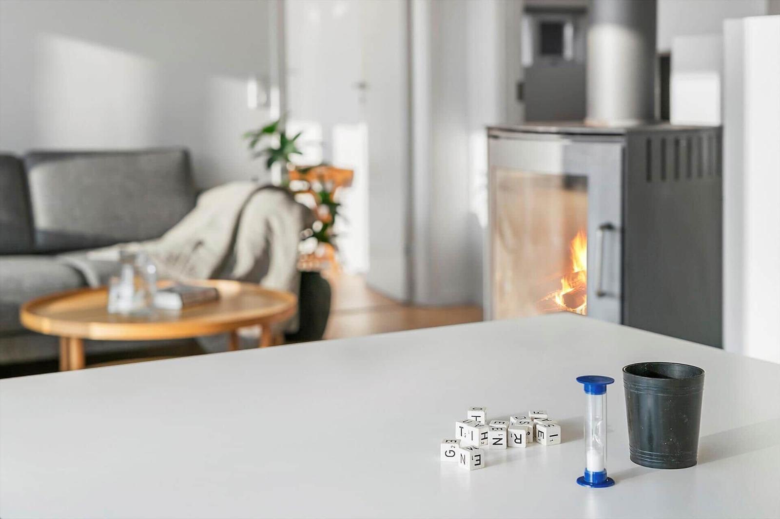 Kitchen with counter, living room with fireplace and sofa in background.