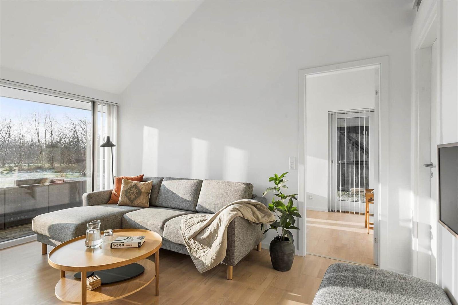 Living room with sofa, coffee table, and view of garden.