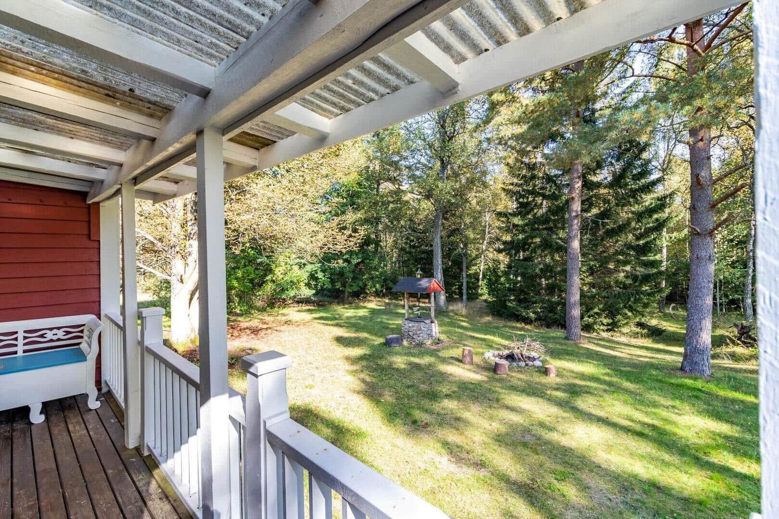 Terrasse mit Blick auf einen Wald und einen Grillplatz.