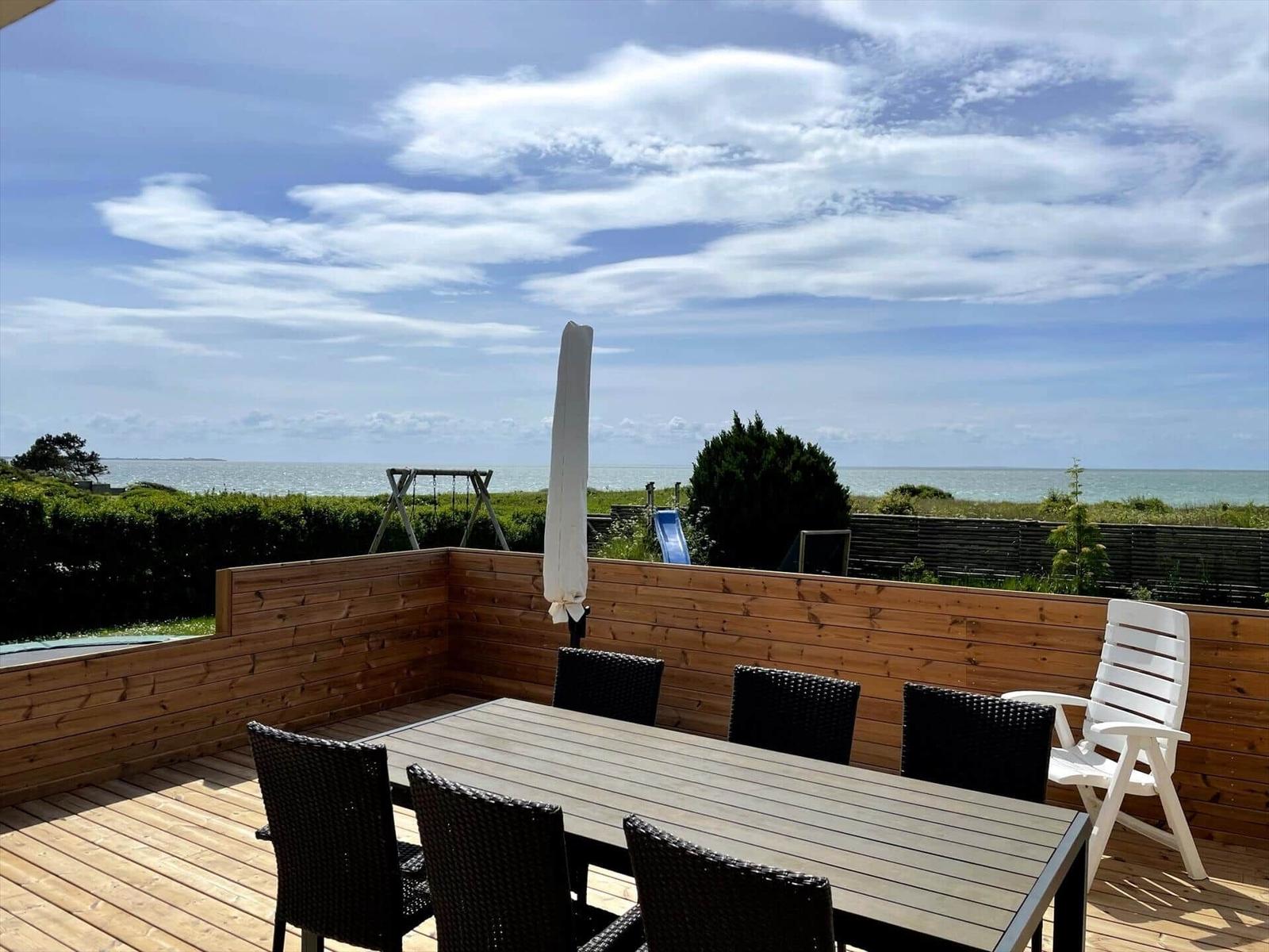 Terrasse mit Tisch, Stühlen und Blick aufs Meer