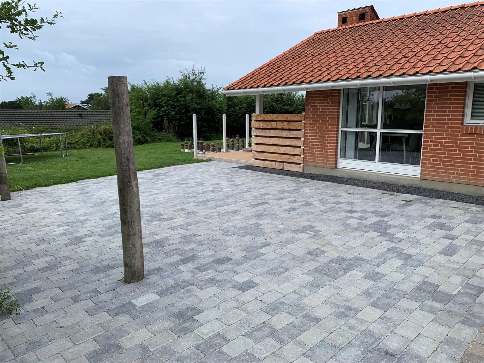 Large paved yard with terrace and shed next to the house.