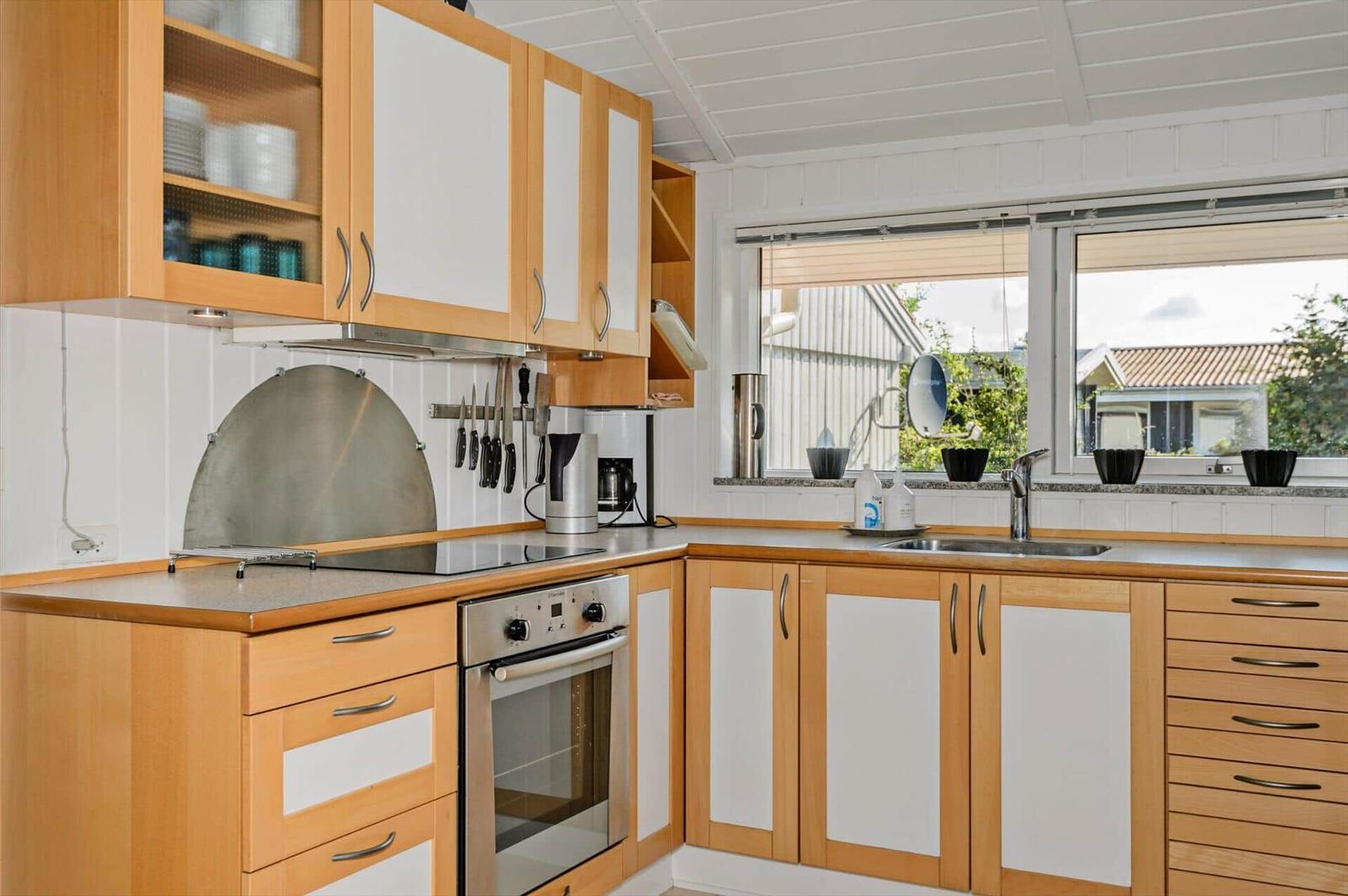 Kitchen with wooden cabinets, stainless steel appliances, and window view of outdoor area.