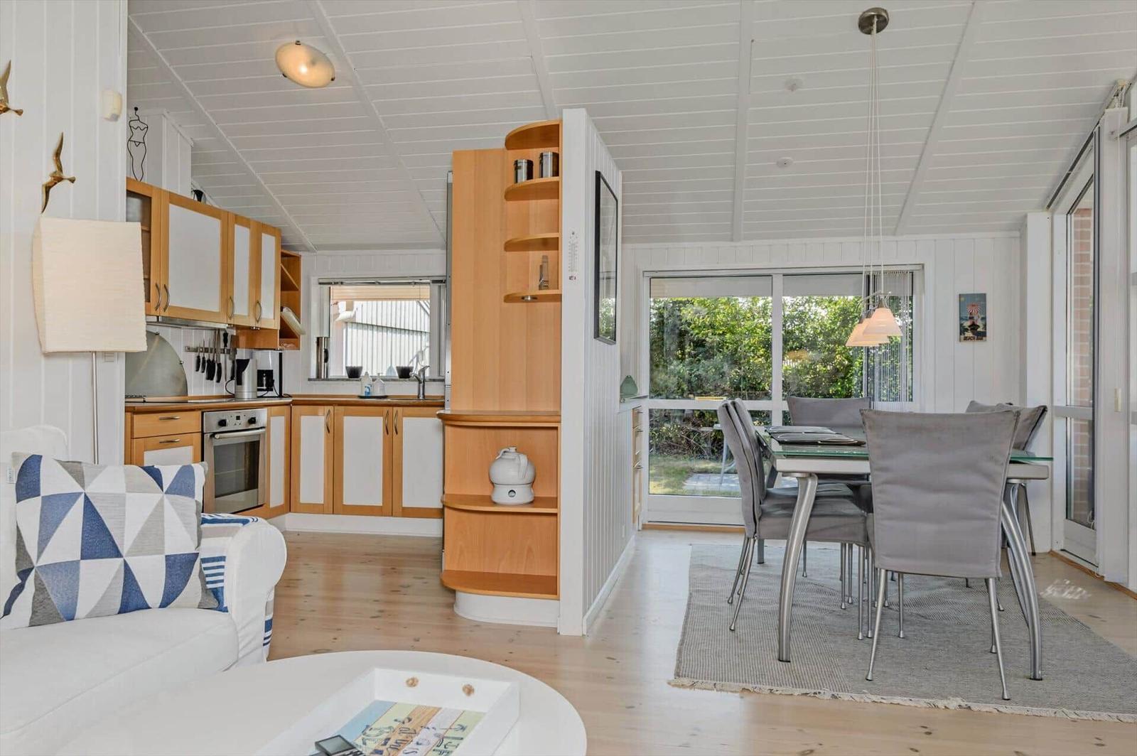 Living and dining area with kitchen and view of the garden.