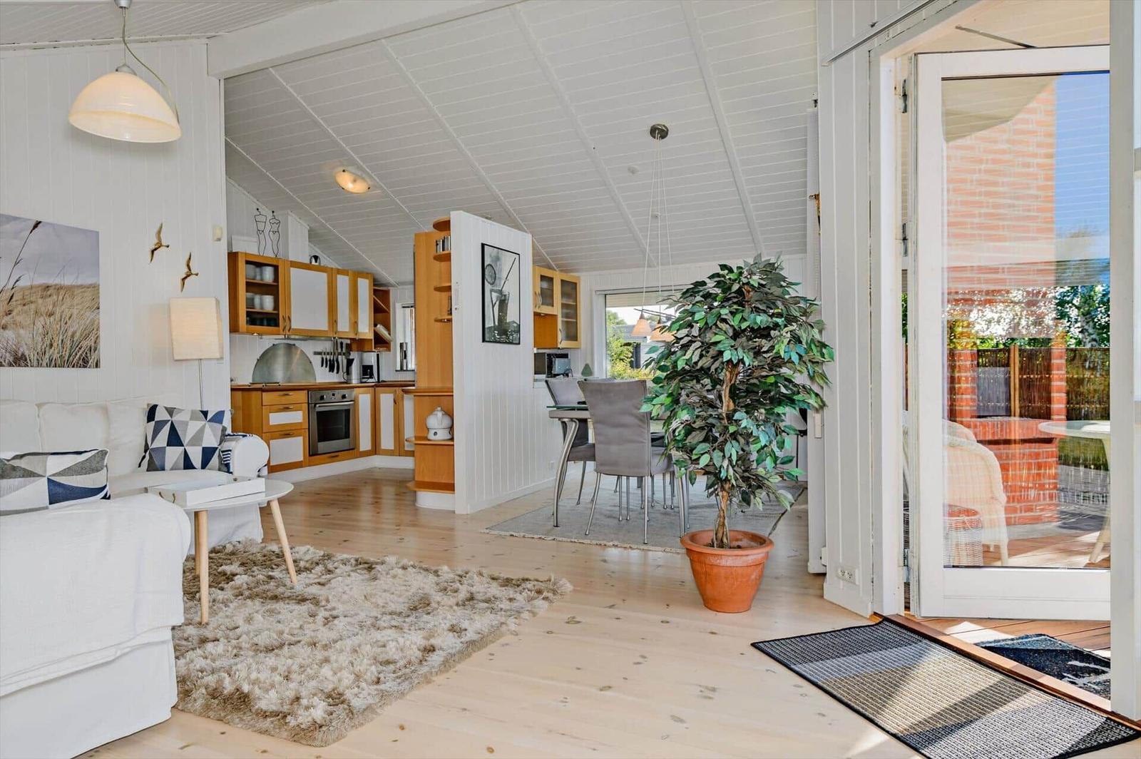 Apartment with kitchen, dining area, and bedroom. Entrance to terrace with view of garden.