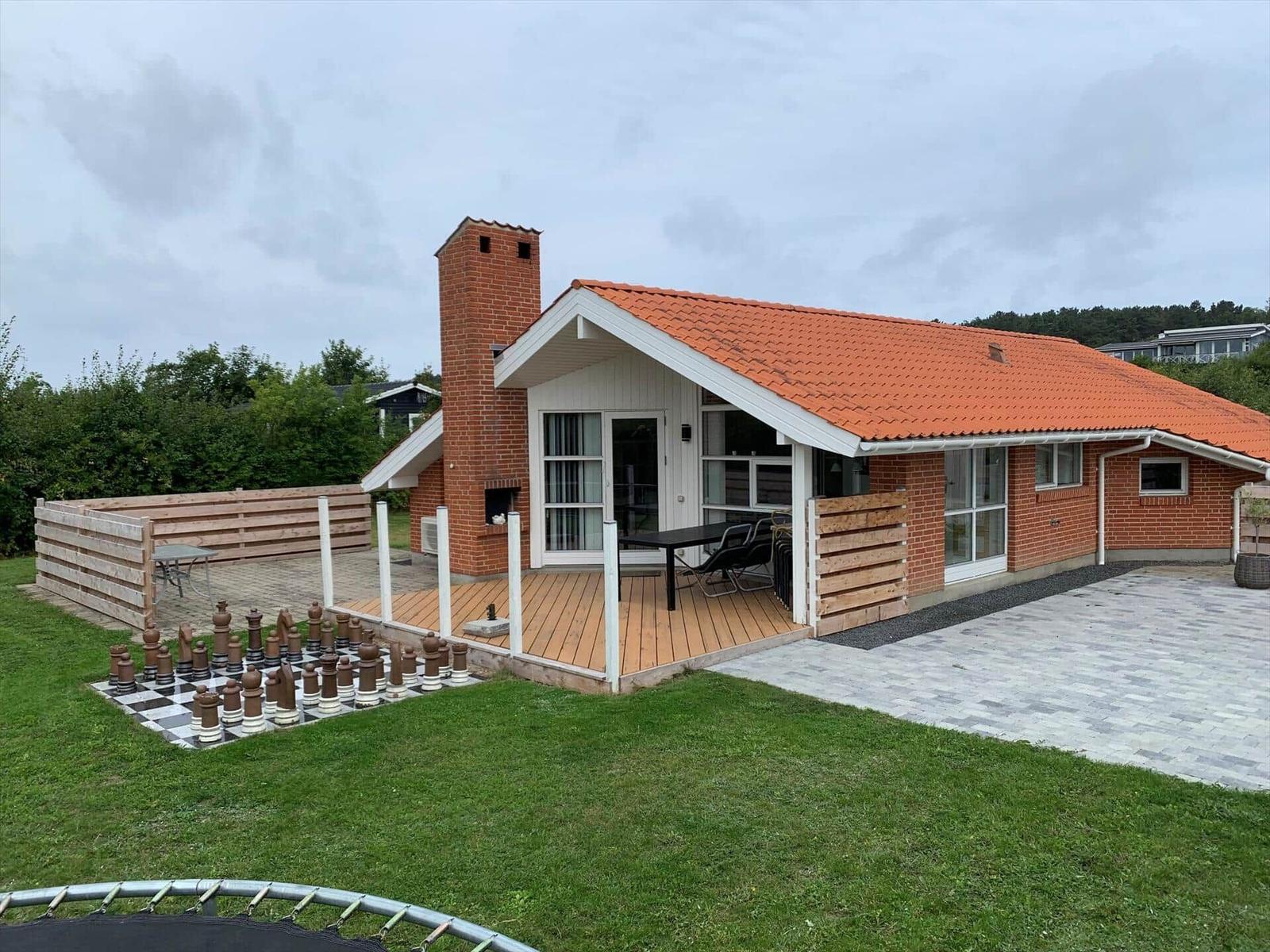 House with terrace, barbecue area, and large chessboard in the garden.